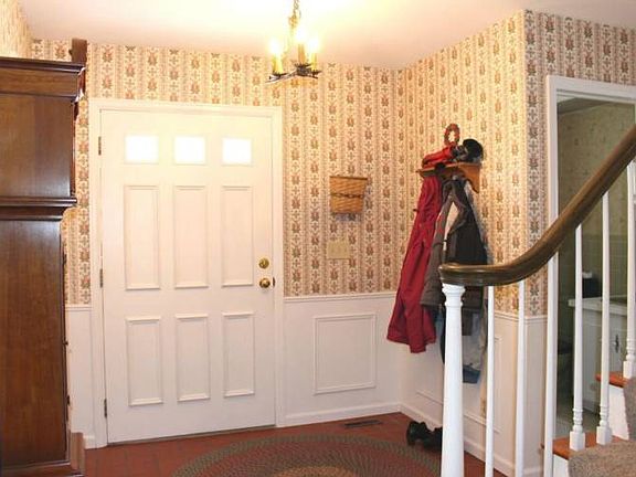 Opposite view shows off the beautiful staircase and 1/2 bath off just off the foyer.