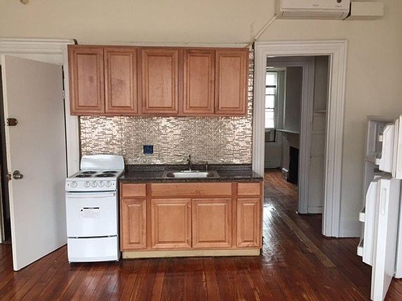 Front door on the left, kitchen and hallway to the bedroom on the right