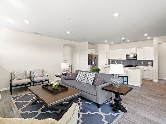 An open floor plan with connected kitchen, dining gathering space with tile floors