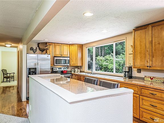 Updated Kitchen w/Rich Cabinetry, Granite Countertops, Tile Backsplash, Stainless Steel Appliances, Breakfast Bar & Can Lighting - Open to Living Space.