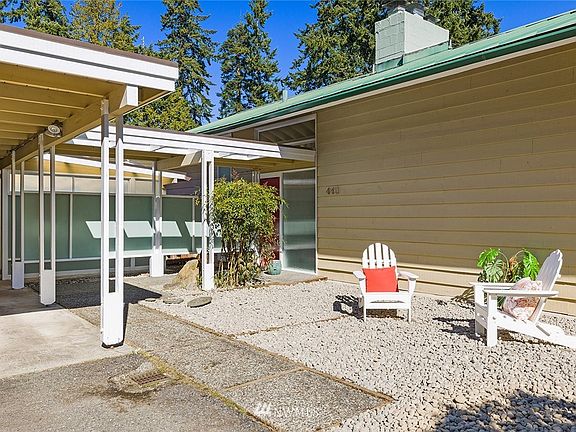 Built in 1956 and true to the  architectural styling of a split level mid century modern home, the 4 bedroom/2 bath home has a covered carport which connects with the home via a covered walk way.  Within but behind the carport are two bonus areas - one which houses a home workshop and the other area that has a very cool finished space which could be used as an office, studio or rec room.