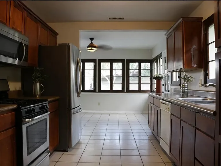 Nice shot of the family room through the kitchen and some of the many french windows-- the scale and proportions of the home combine to create a welcoming, calm space