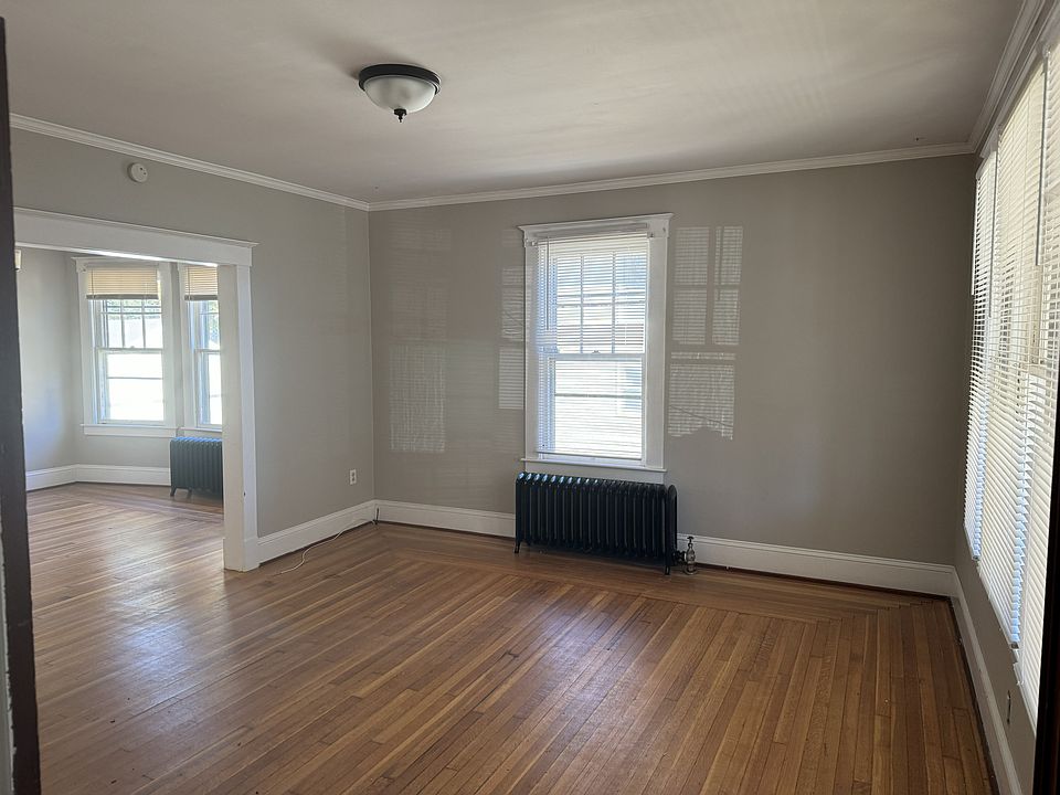 Sun-filled living area with large windows and classic charm throughout.