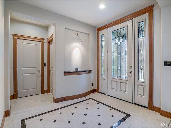 Formal entrance with tile floor and wood mill-work. 