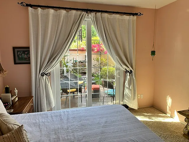 Primary bedroom has a sliding glass door that looks out to lovely serene garden. Pottery Barn blackout curtains remain in condo to ensure your peaceful sleep.