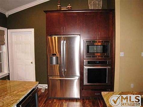 Acacia wood flooring throughout kitchen. Oversized Thermador refrigerator and Miele Oven.