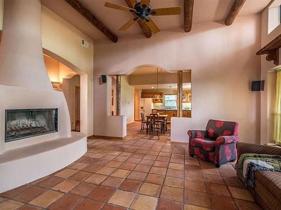 Great room with wood burning fireplace , high ceilings, wood beams and tile.