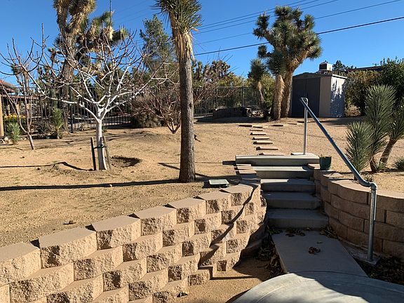 Multi level yard with fruit trees and retaining block wall