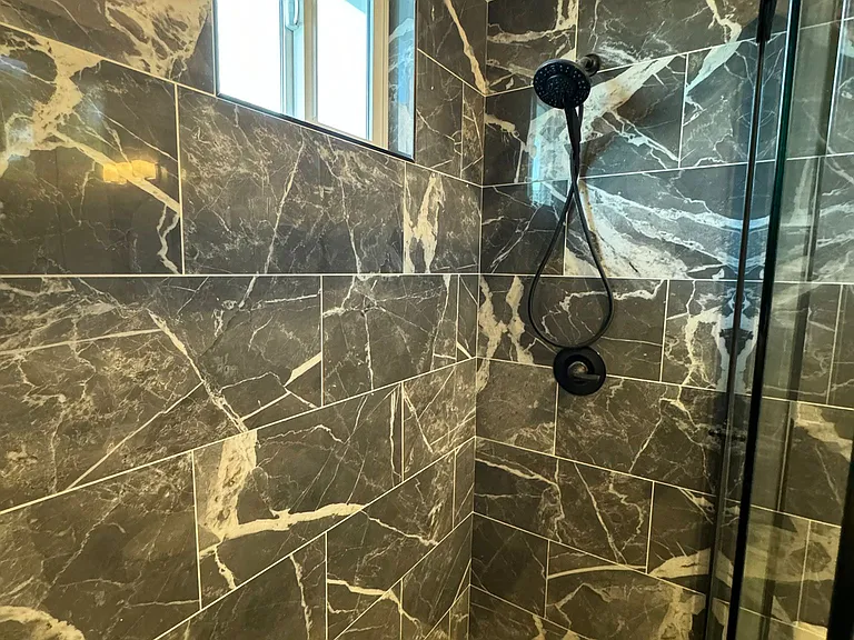 Guest bathroom with high glass, all tile and niche. Removable shower wand.