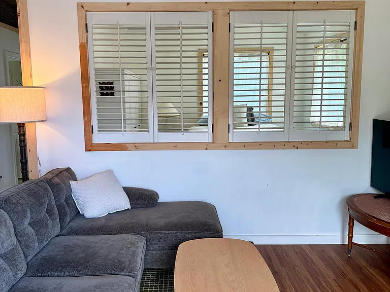 Peakaboo window into the bedroom from the living room space, gives the living room a more expansive feel.