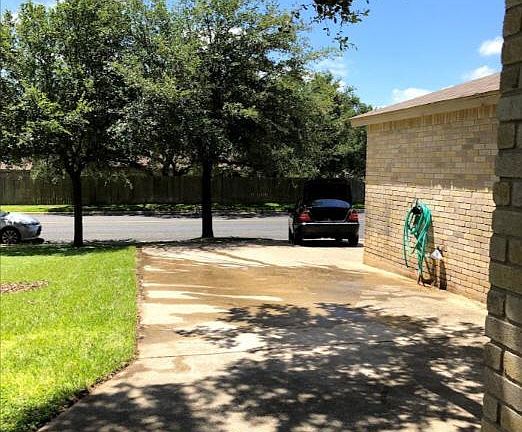 An extended (wide) driveway with shade fits three cars.