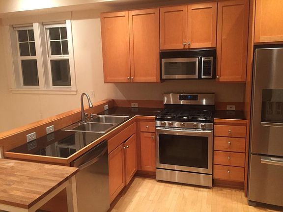 Kitchen with dishwasher, gas range and oven, refrigerator.