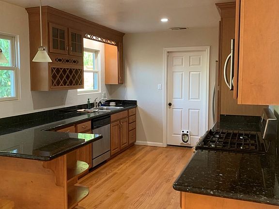 kitchen with stainless steel appliances, granite countertops and wine rack.