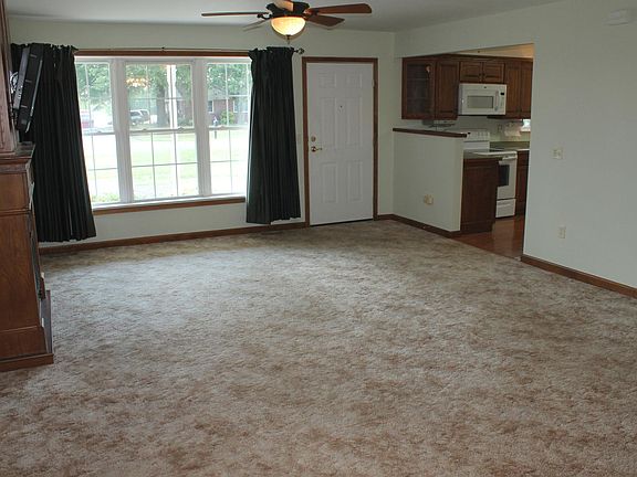 Living/Dining room looking from back of house toward front door and kitchen.