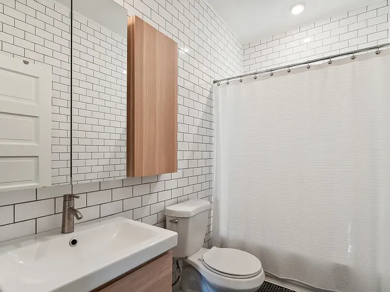 Second bedroom located in the hallway between the two bedrooms. Bathtub and window are covered by the shower curtain.