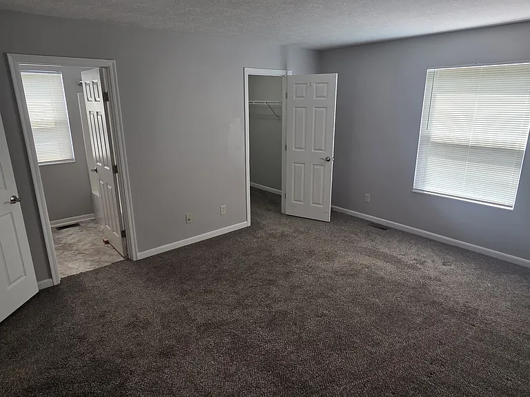 Primary bedroom with attached bathroom and walk-in closet