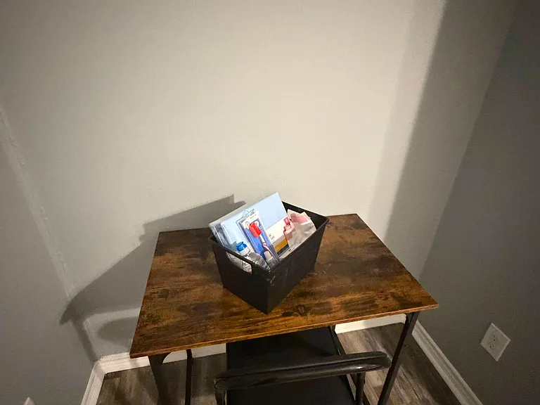 Compact work nook with a sturdy desk and chair, set on durable wood-look flooring for easy everyday use.