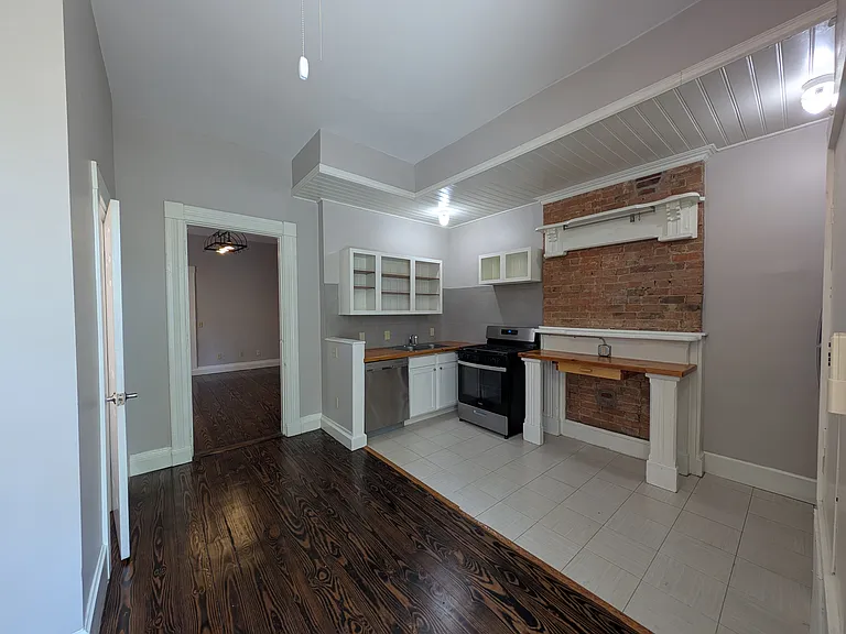 Kitchen includes gas stove, stainless steel appliances, and handmade wooden countertops.