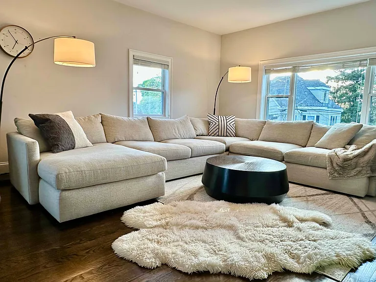 Spacious, sun-filled living room with hardwood floors and flexible space for relaxing, entertaining, or play.