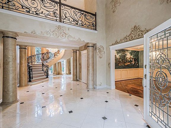 The beveled lead glass doors are lovely. Dining room to the right and formal living room to the left. Decorative customized crown molding is found throughout the house.