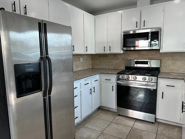 Kitchen with microwave over range and refrigerator included.