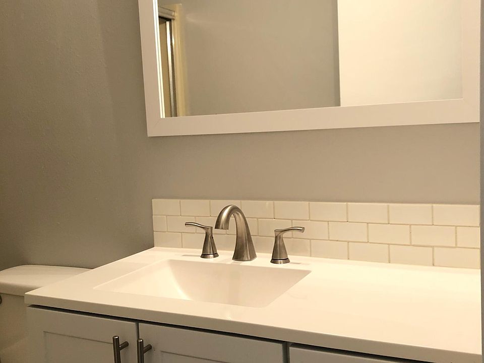 Newly renovated bathroom sink, vanity, mirror, and toilet .
