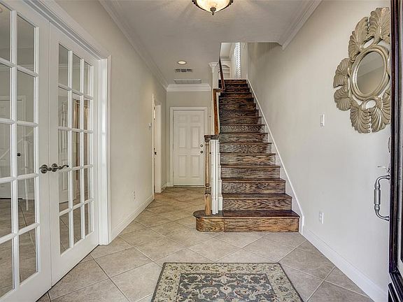 Front Entry: Tile first floor has a large foyer tiled to garage access. Generous closet under the stairway. The stained hardwood treads and handrail to floor two.