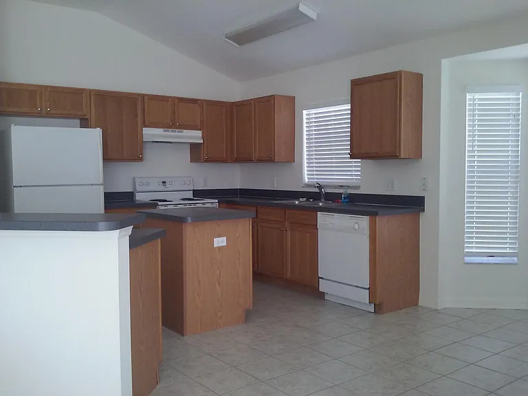 Kitchen Area; Walk-in Pantry to left (out of frame) next to Refrigerator. Bump-Out Seating Area to right for table and chairs. 
Vaulted Ceilings throughout home. 
Patio Space (10'x10') outside to right side, out of frame.