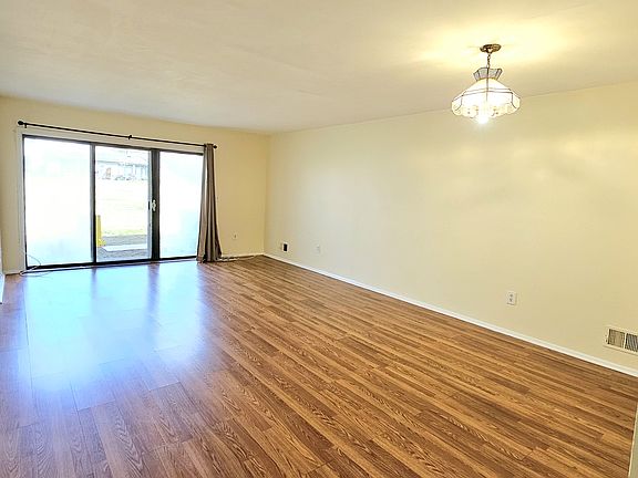Living room gets plenty of natural light and opens to large beautiful green space in the back