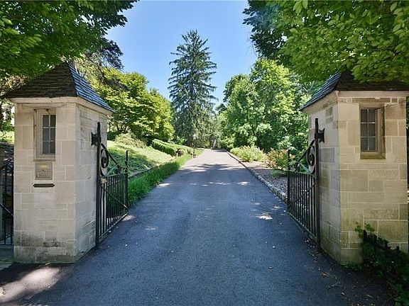 Stone and iron gates flank the long driveway