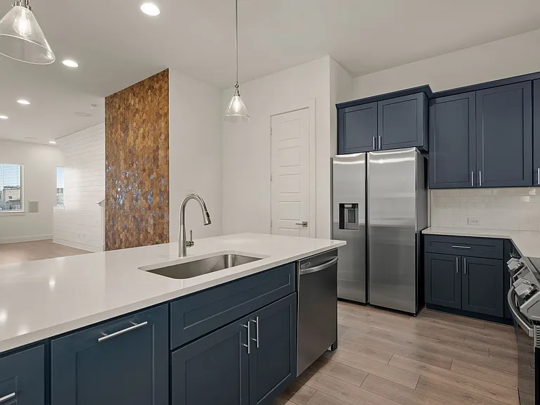 Kitchen view with beautiful island that seats four with elegant pendant lighting. Ample cabinets for extra storage.