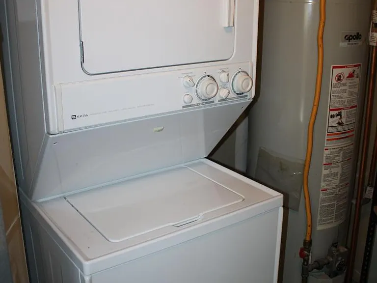 in unit washer & dryer; additional large metal storage shelving also exists in this closet.