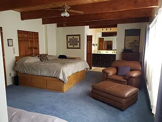 Master suite downstairs: king bed with six drawers underneath, two windows on the lake, plus a third window in the tiled shower, two closets, ceiling fan, baseboard heater, wall heater in toilet room, new double sink, marble vanity with slow-close drawers