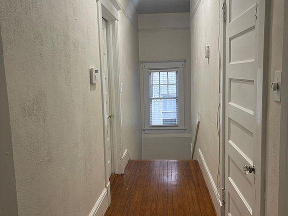 View from apartment looking at stairs from entrance. Front bedroom to right and bedroom with bathroom to left in this photo.