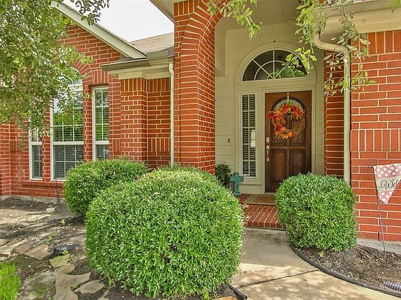 Guests will feel welcomed by this beautiful brick porch with wood door and sidelight.