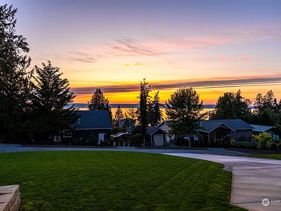 Fully landscaped yard with large grass lawn>