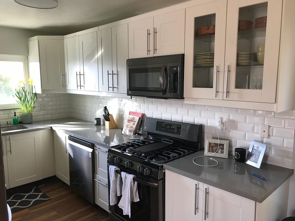 Updated kitchen with quartz countertops, subway tile backsplash, newer appliances. Includes refrigerator, dishwasher, gas range, and built-in microwave.