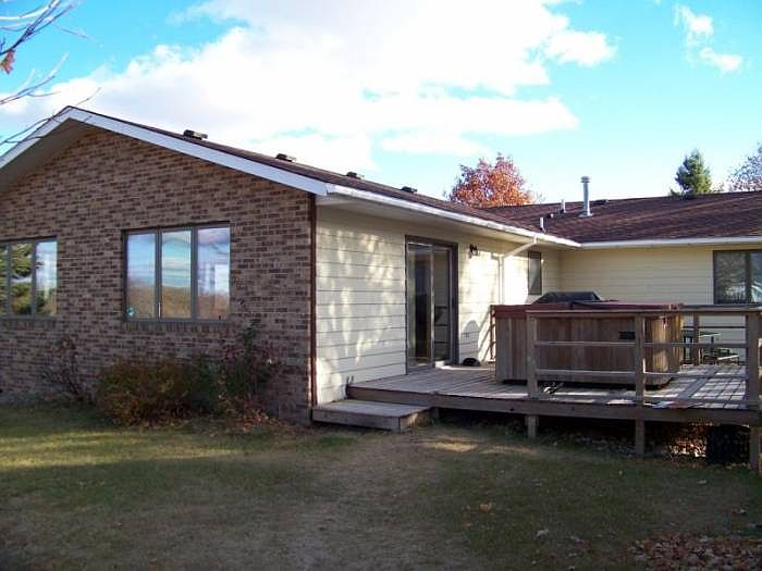 Back of home with hot tub