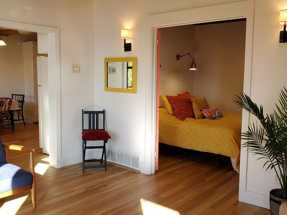 Light-filled living room. View of bedroom 1 and partial view of kitchen.