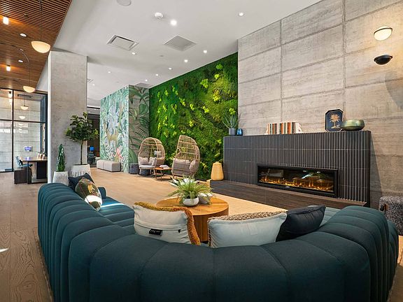 Step into a modern lounge with a fireplace, a comfortable couch, and a striking green wall.