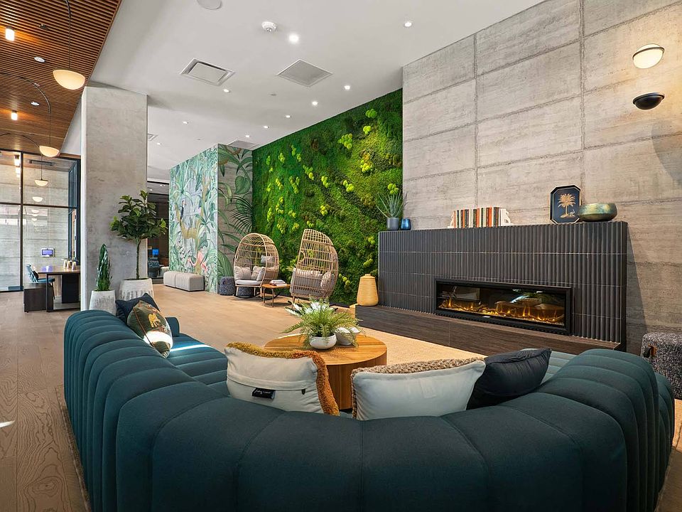 Step into a modern lounge with a fireplace, a comfortable couch, and a striking green wall.