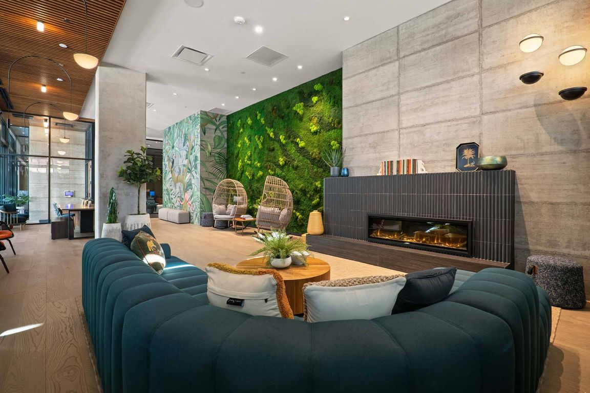 Step into a modern lounge with a fireplace, a comfortable couch, and a striking green wall.