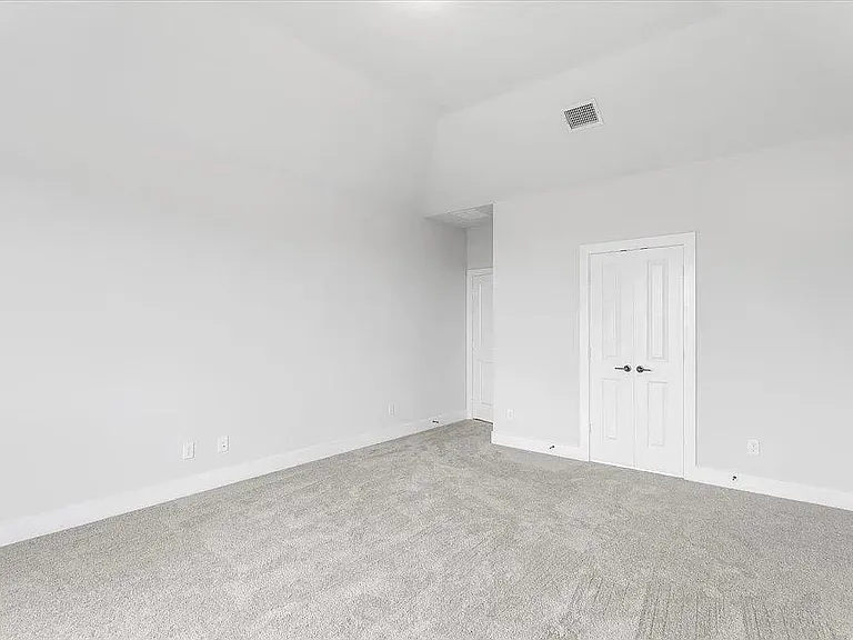 Room featuring vaulted ceilings and light-toned wall finishes