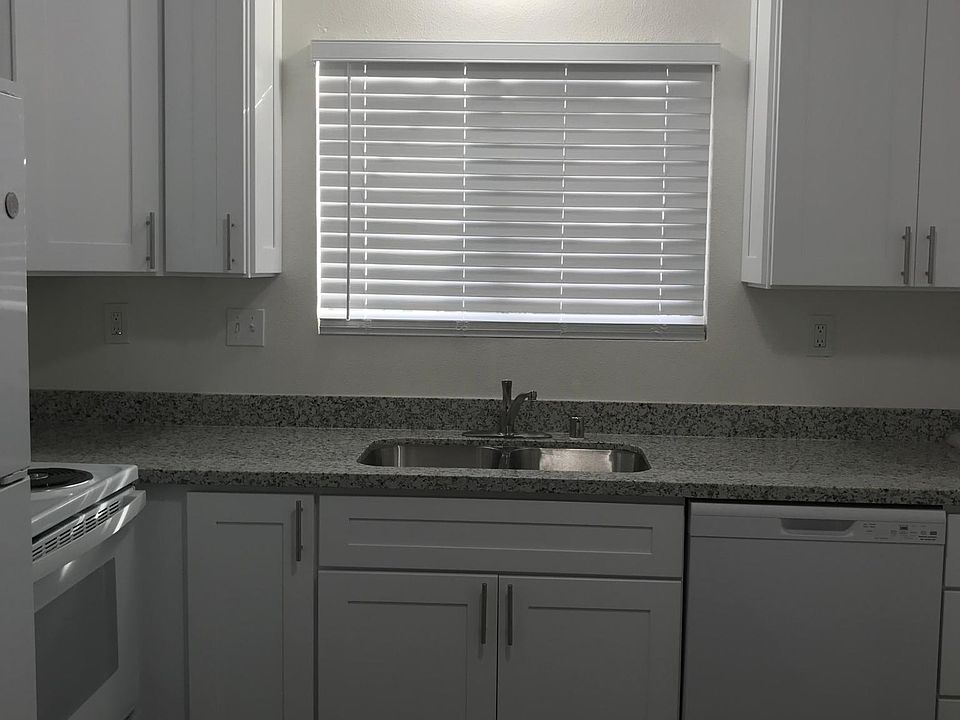 Kitchen with granite countertop, electric stove and microwave