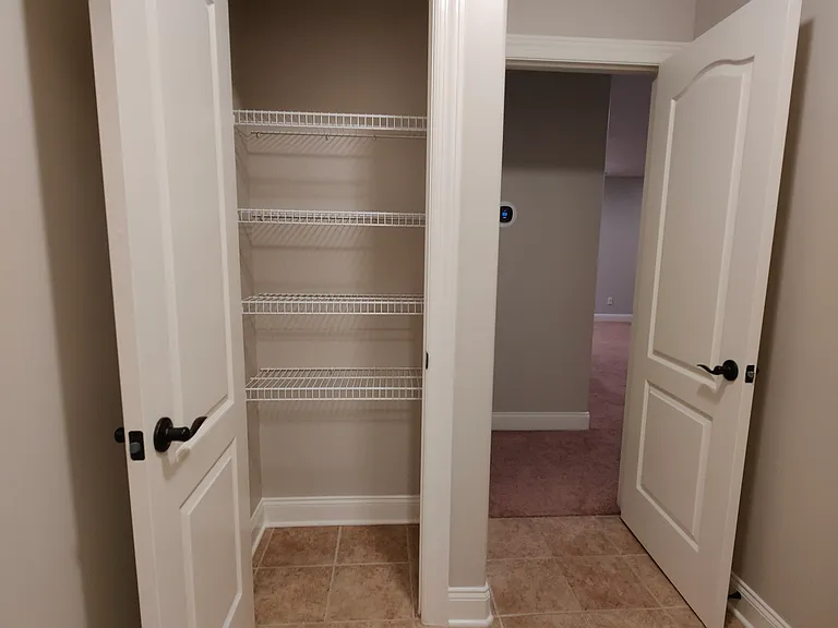 The walkway to upstairs bathroom has a storage with door.