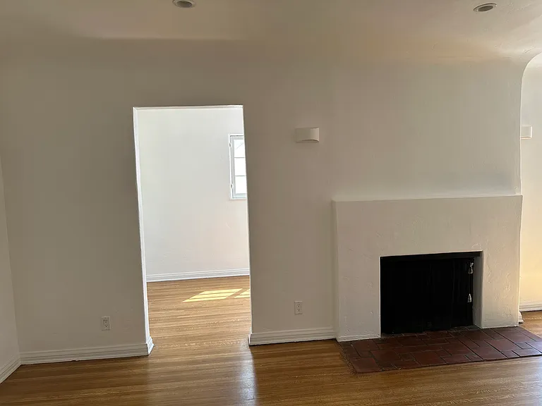 Living room with wood burning fireplace, entry door to office