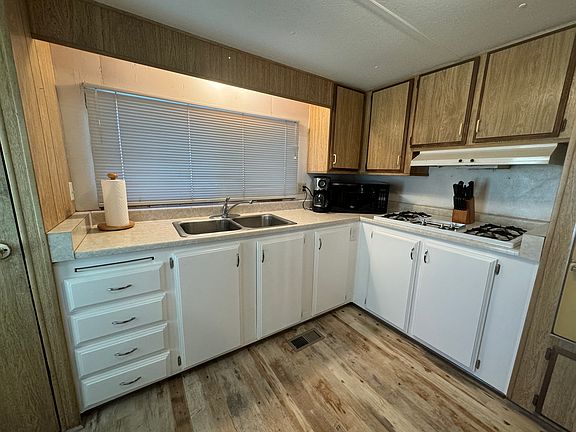 Kitchen with view window to the front yard, pantry, microwave and range. White refrigerator and 4 seat round farm table not shown.