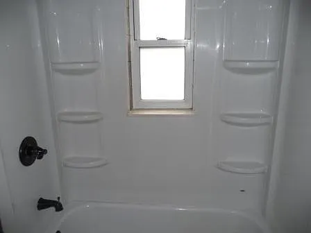 White tub shower surround with oil rubbed bronze fixture finishes. Privacy window that lets light in and blocks images out!