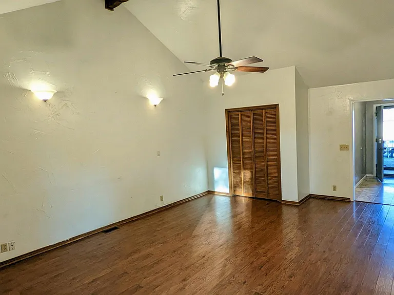 Living room with wet bar, looking towards the foyer, beautifully lit with engineered wood, perfect for pets, & easy to clean!