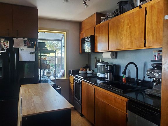 Kitchen with granite countertops, ceramic cooktop, built in microwave, and large fridge with bottom freezer.
